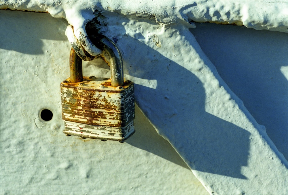 a rusted padlock attached to a white wall