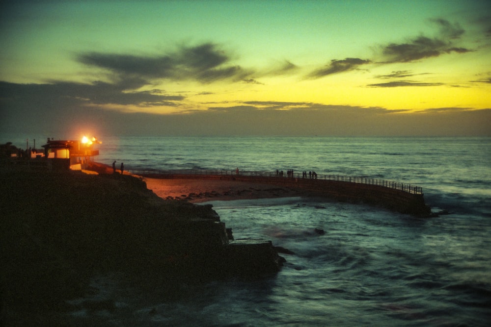 a light house on the edge of a cliff by the ocean