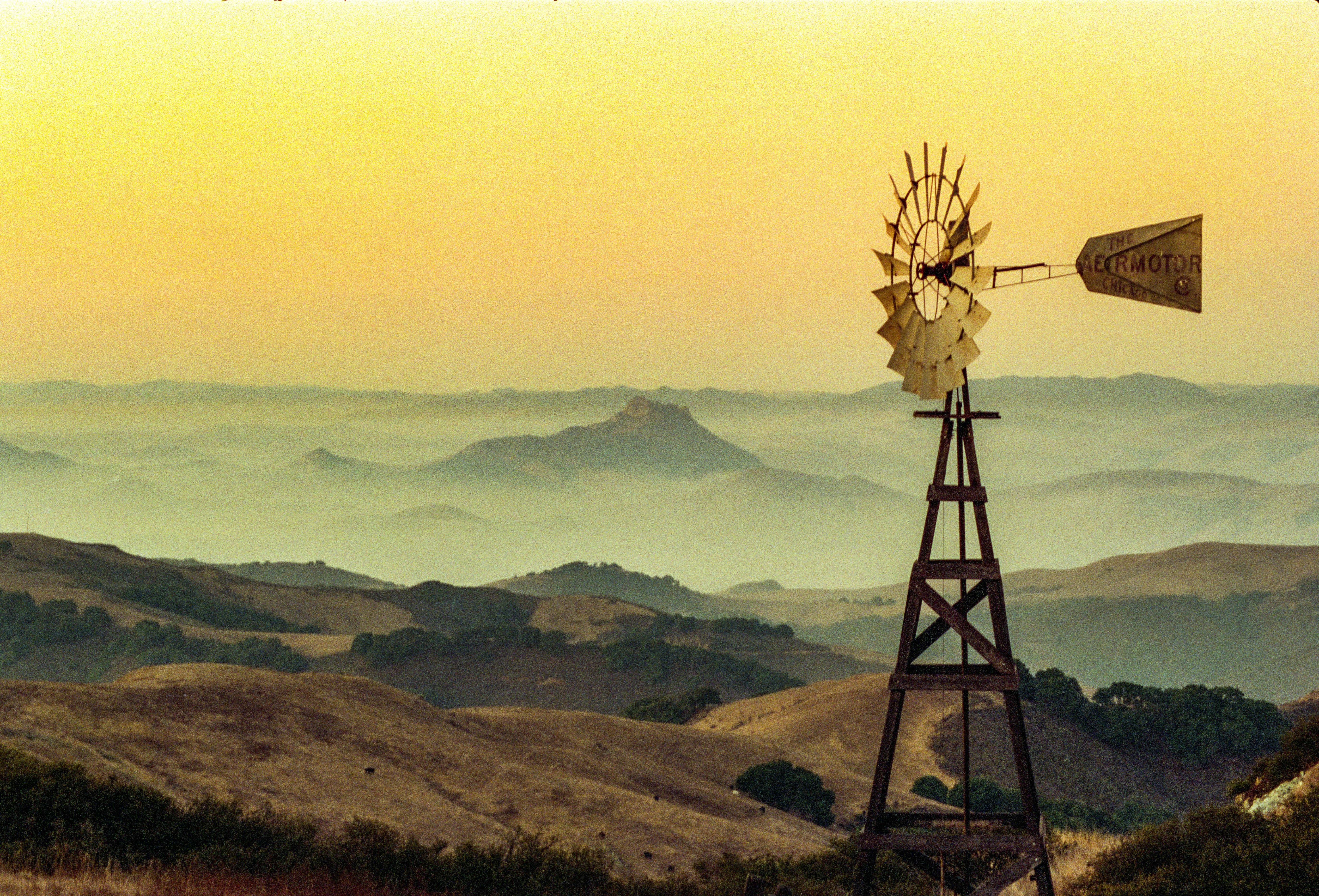 a windmill on top of a hill with a sky background