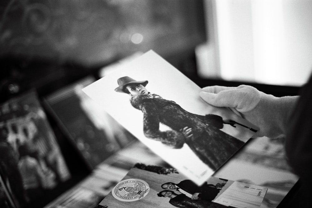 a person holding a card with a picture of a man in a hat