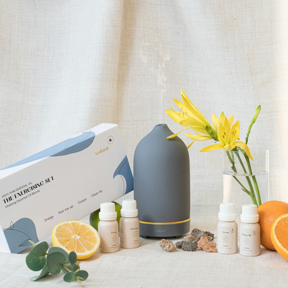 a table with a vase, bottles, and oranges on it