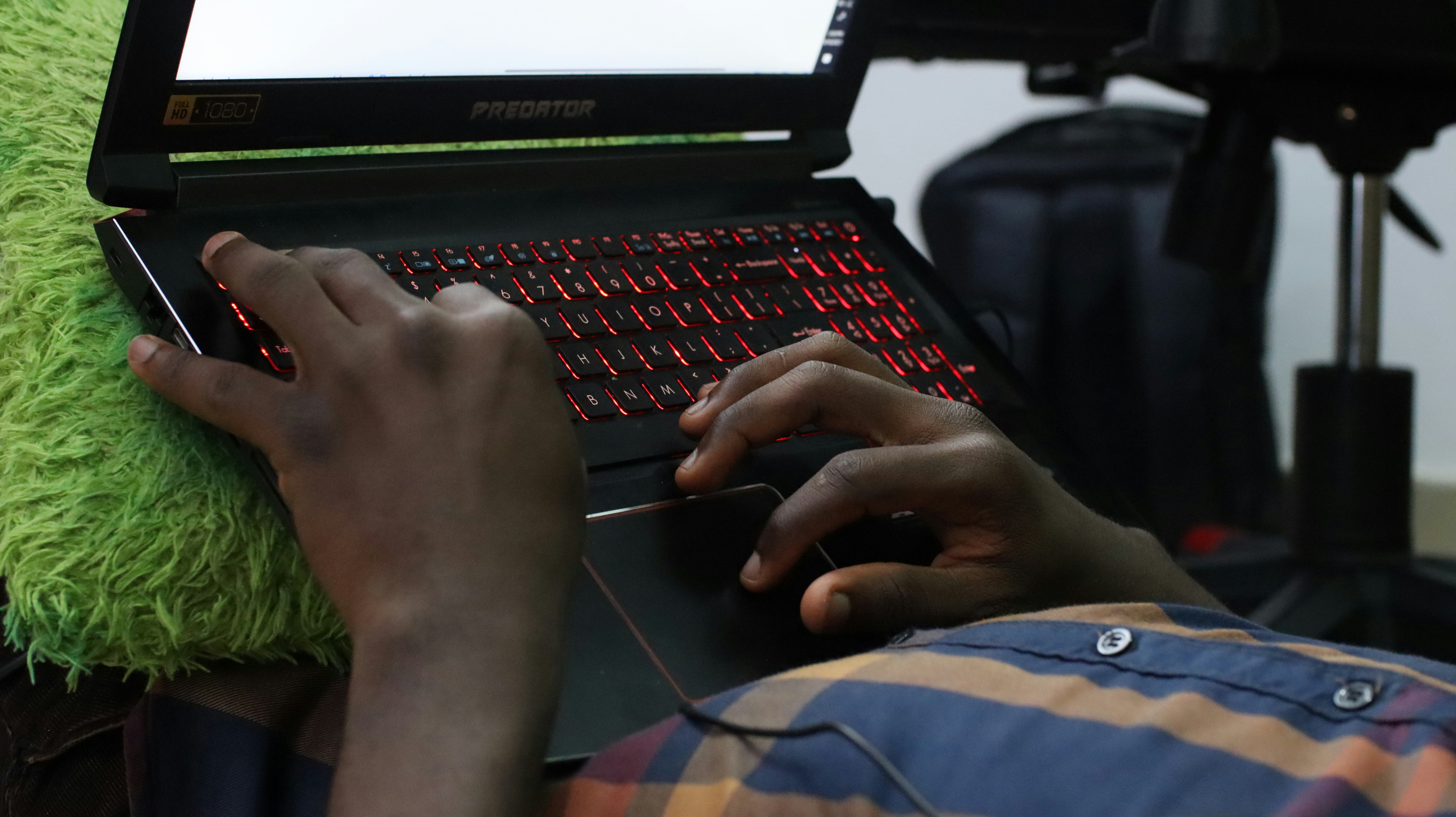 a man is typing on a laptop computer