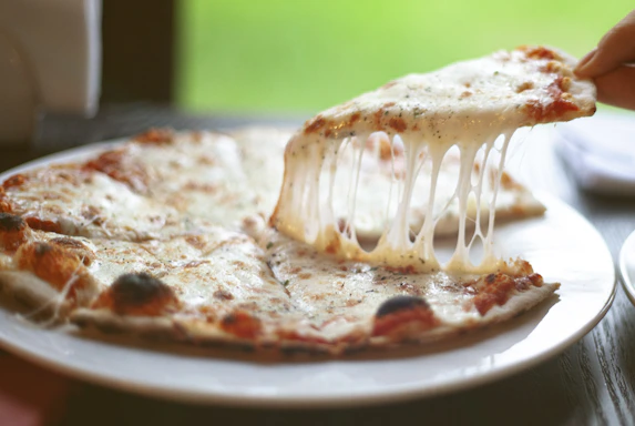 a slice of pizza being lifted from a plate