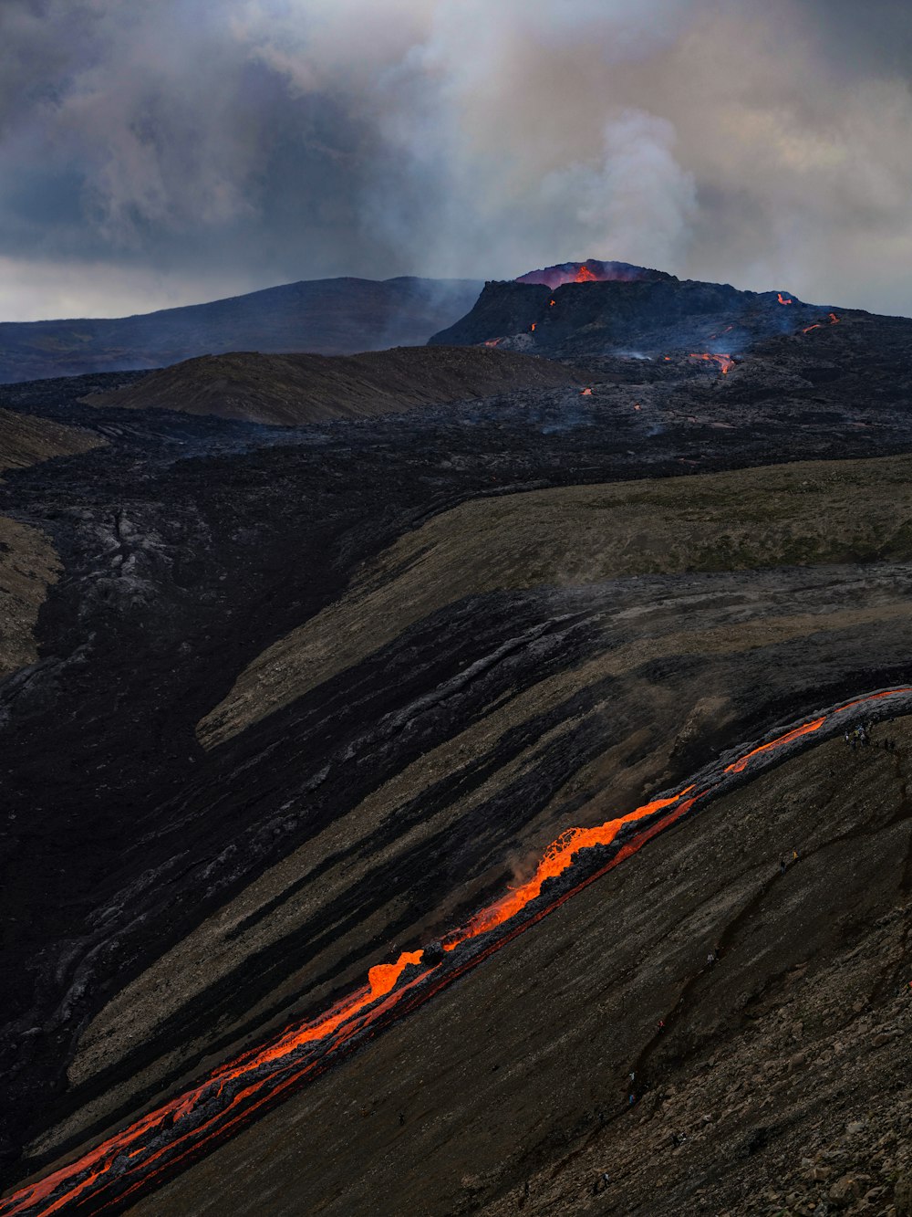 un volcán con lava fluyendo por el costado