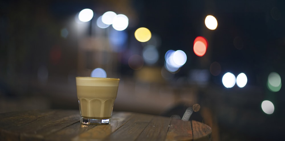 a cup of coffee sitting on top of a wooden table