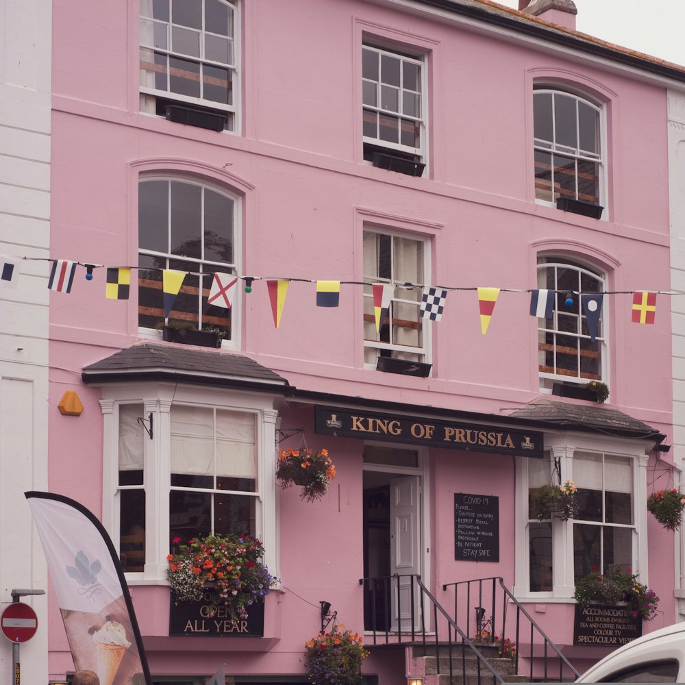 a pink building with flags hanging from it's windows