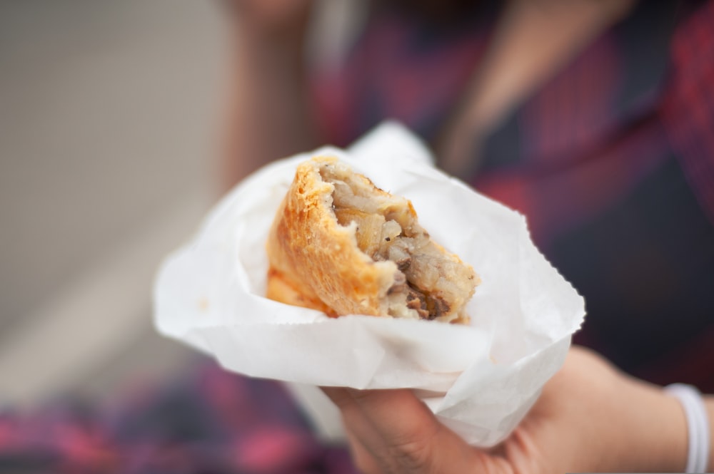 a close up of a person holding a pastry