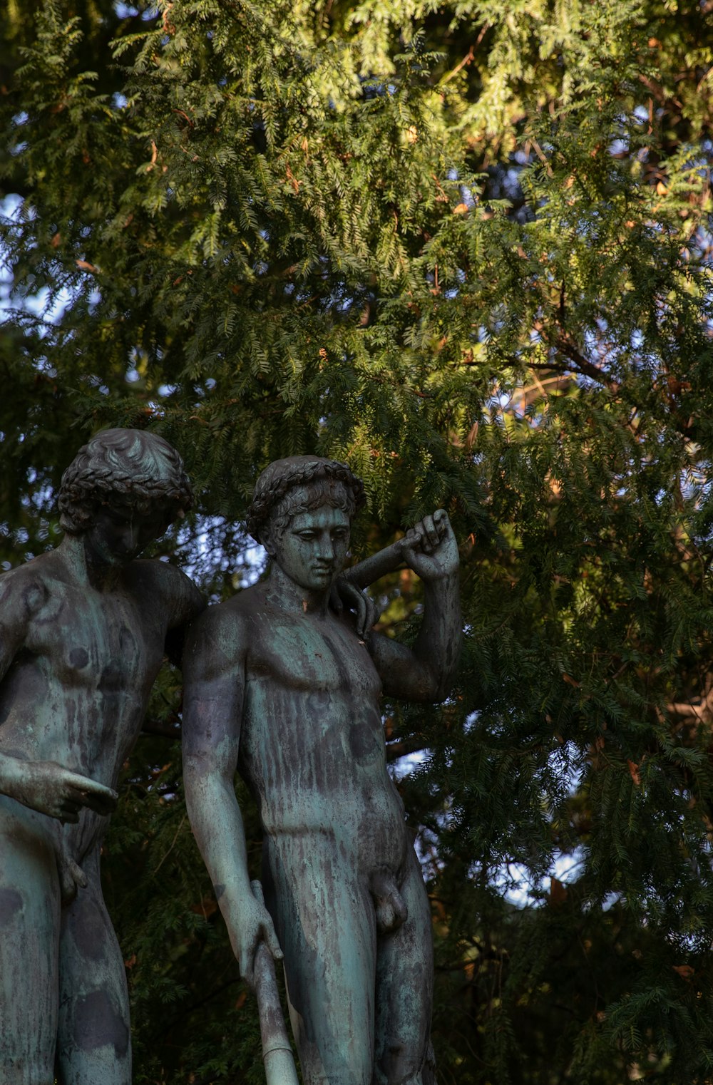a statue of two men holding a trumpet