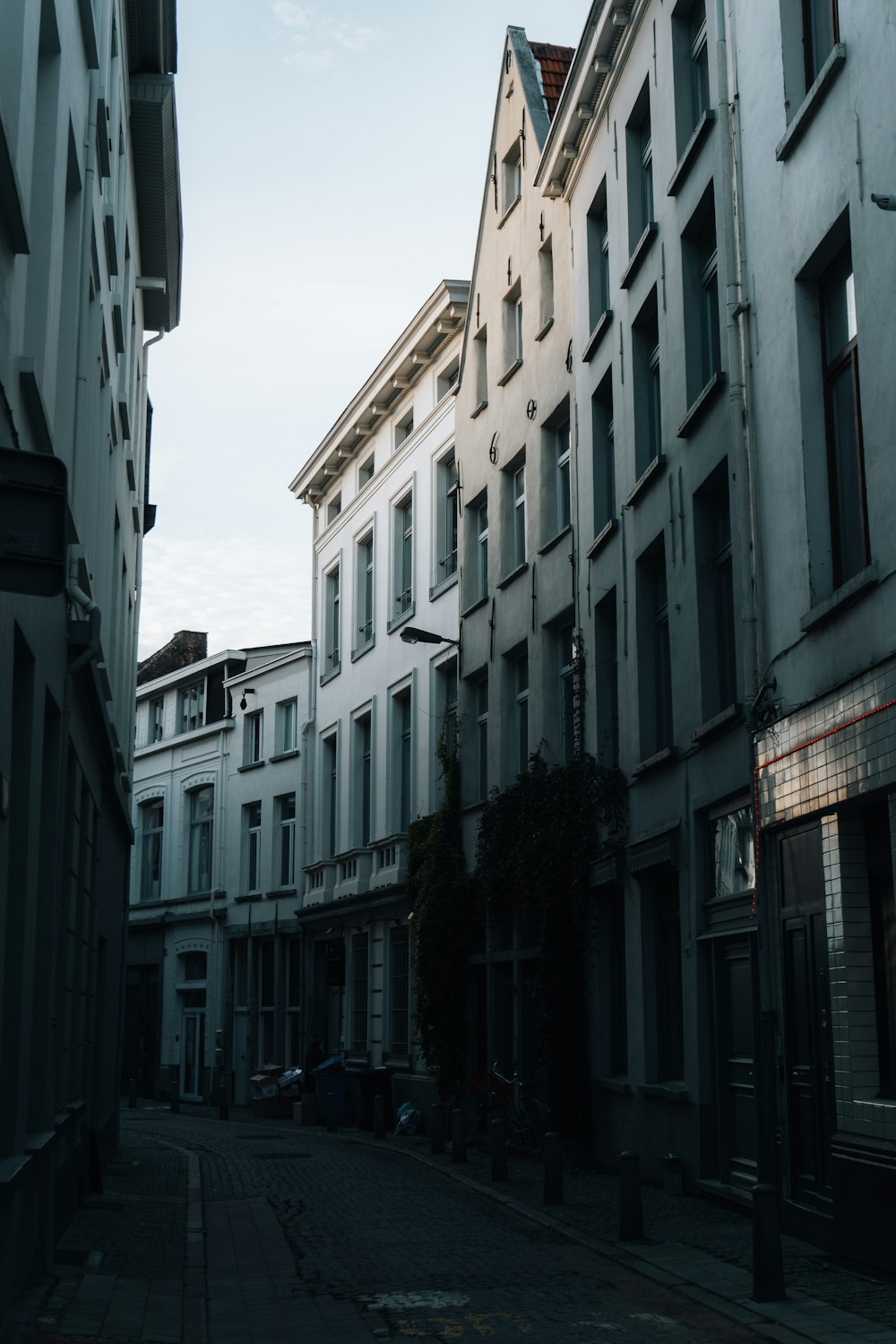 a narrow street lined with tall white buildings