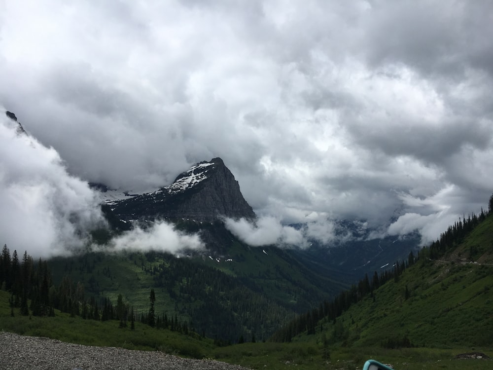 a view of a mountain with clouds and trees