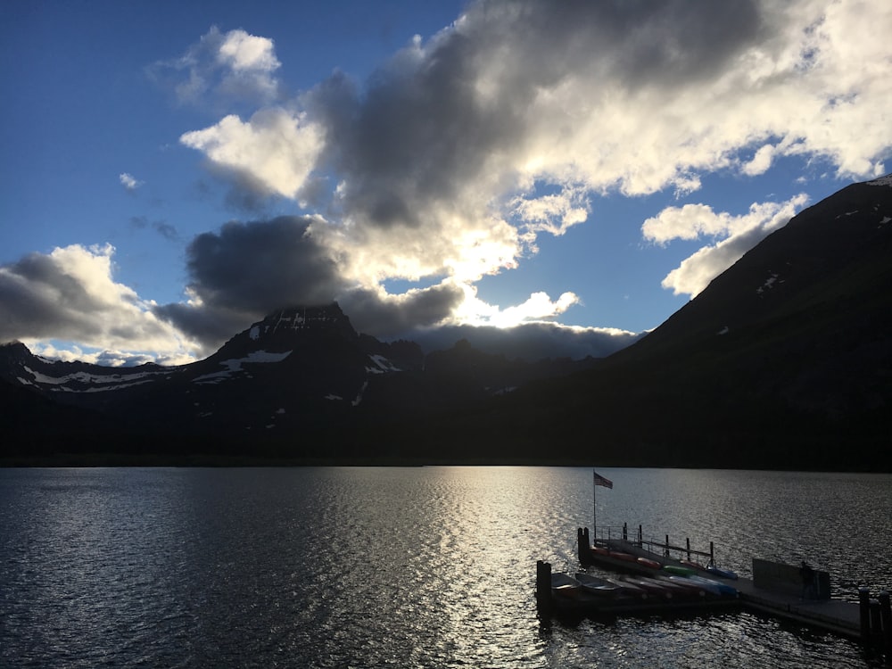 a lake with a boat in it and mountains in the background