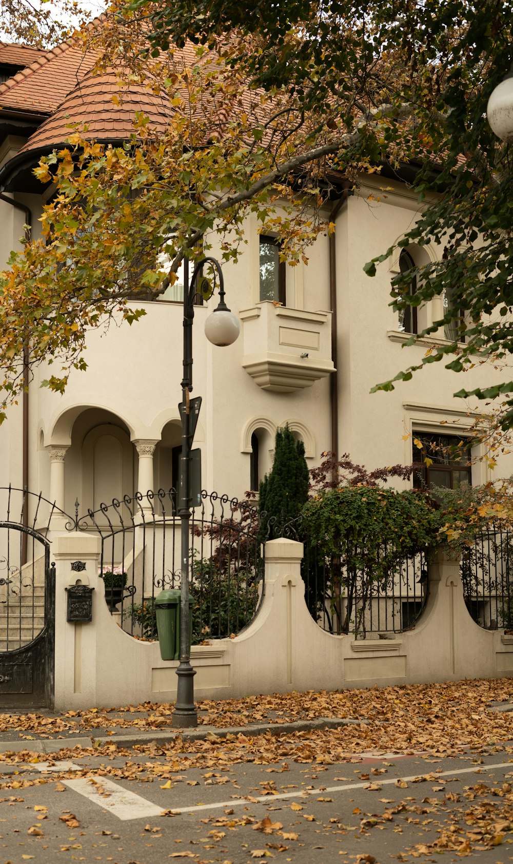 a white house with a black fence and a street light