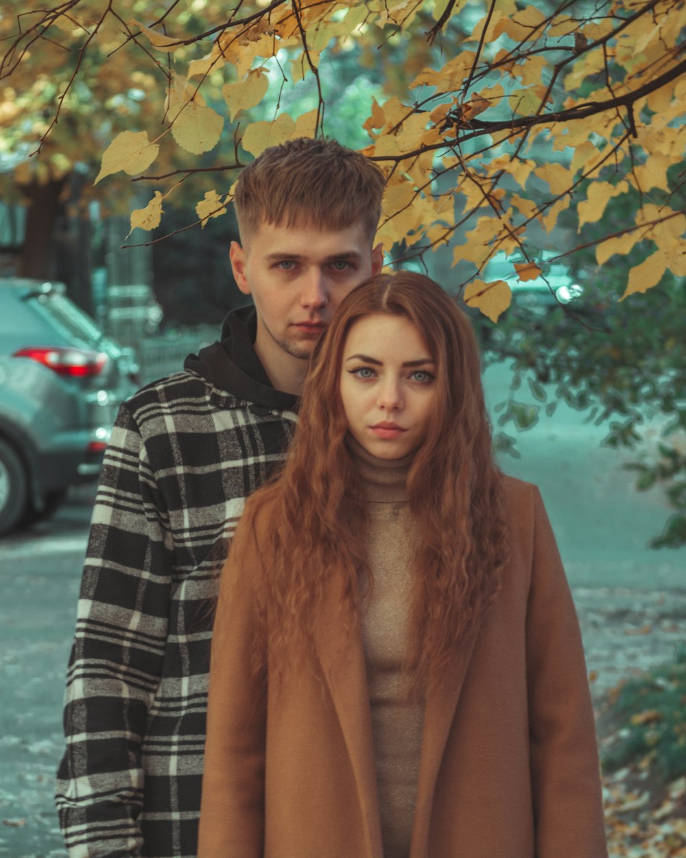 a man and a woman standing under a tree