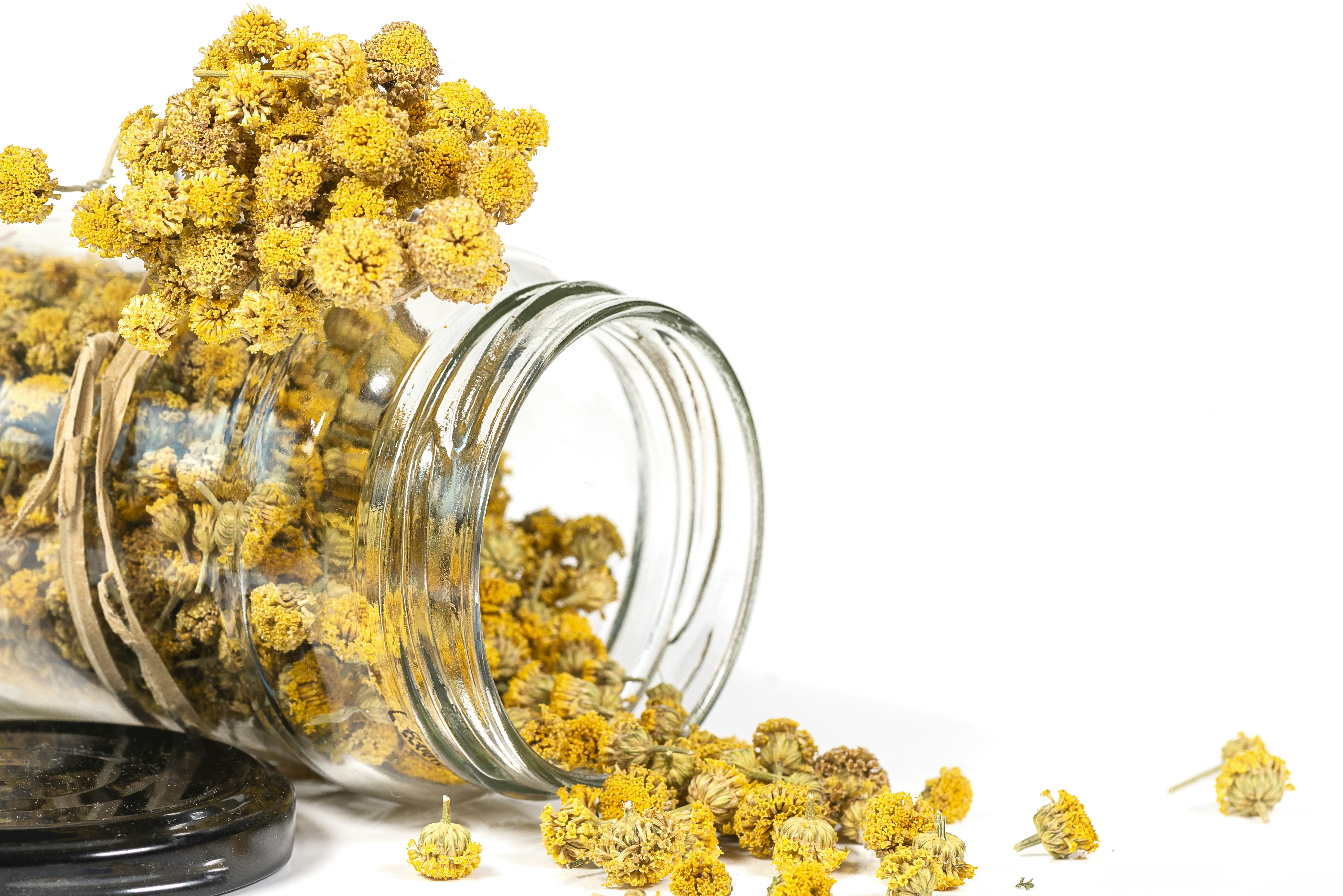 a jar filled with yellow flowers sitting on top of a table