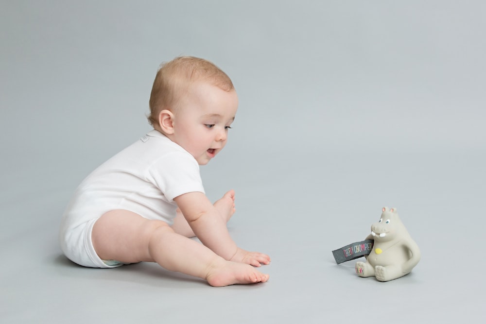 a baby is playing with a toy bear