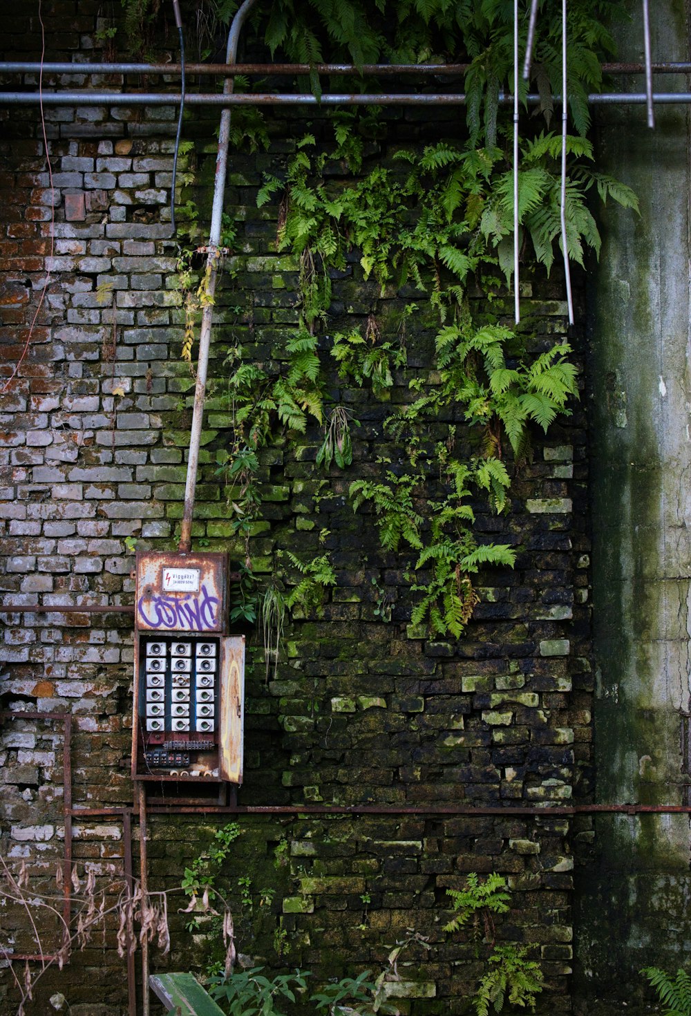 an old machine sitting in front of a brick wall