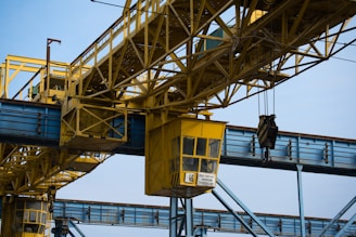 a yellow crane is attached to a metal structure