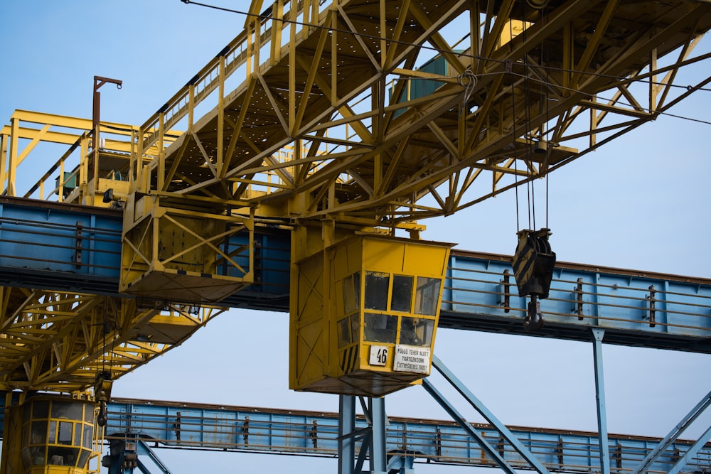 a yellow crane is attached to a metal structure