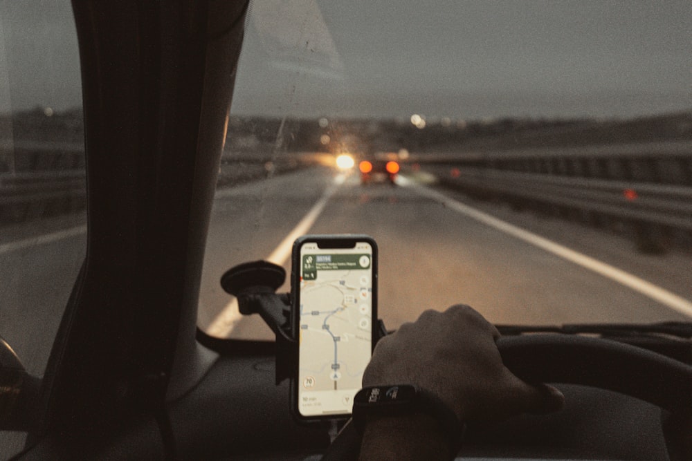 a person holding a cell phone in a vehicle