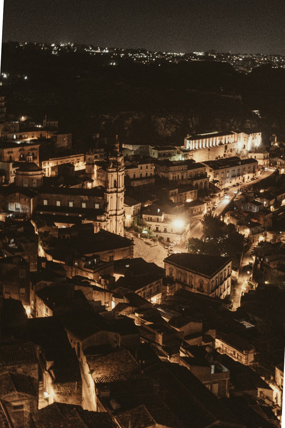 uma vista de uma cidade à noite de um ponto de vista alto
