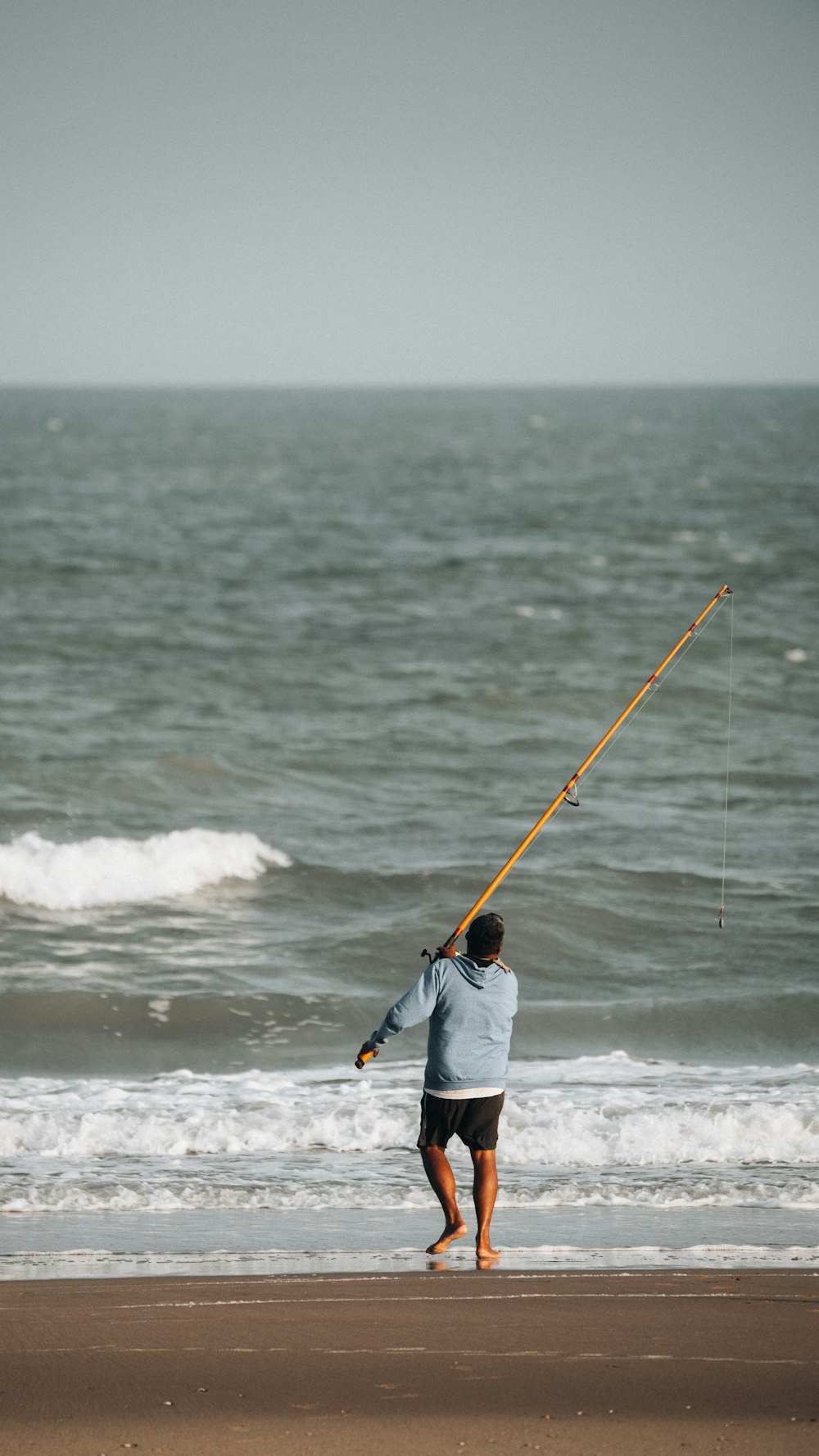 a man on the beach flying a kite