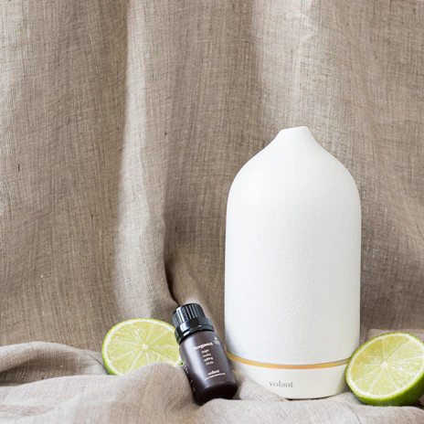 Close-up of smooth aroma diffuser stones resting on a soft linen cloth, bathed in warm natural light.