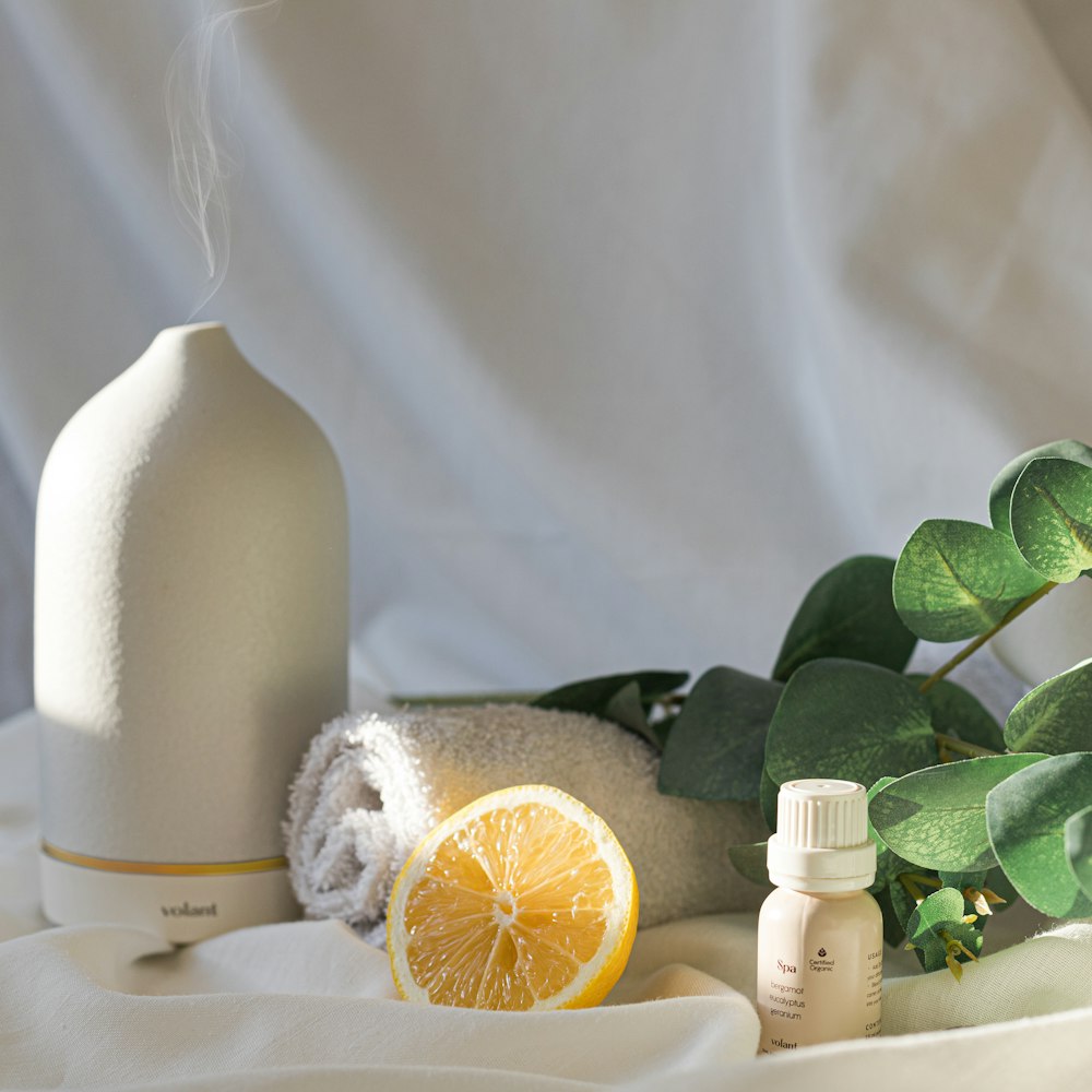 a bottle of essential oils next to a lemon