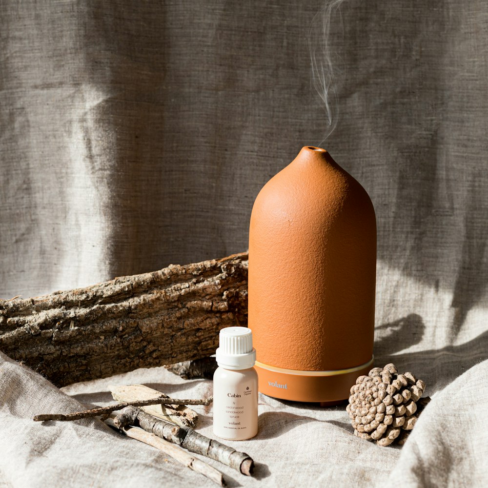 a bottle of liquid sitting next to a pile of wood