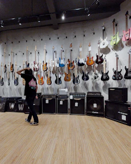 A music instructor demonstrating guitar chords in a bright, inviting room.