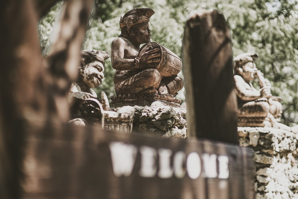 a statue of a man sitting on top of a wooden bench