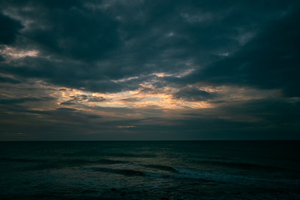 o sol está brilhando através das nuvens sobre o oceano