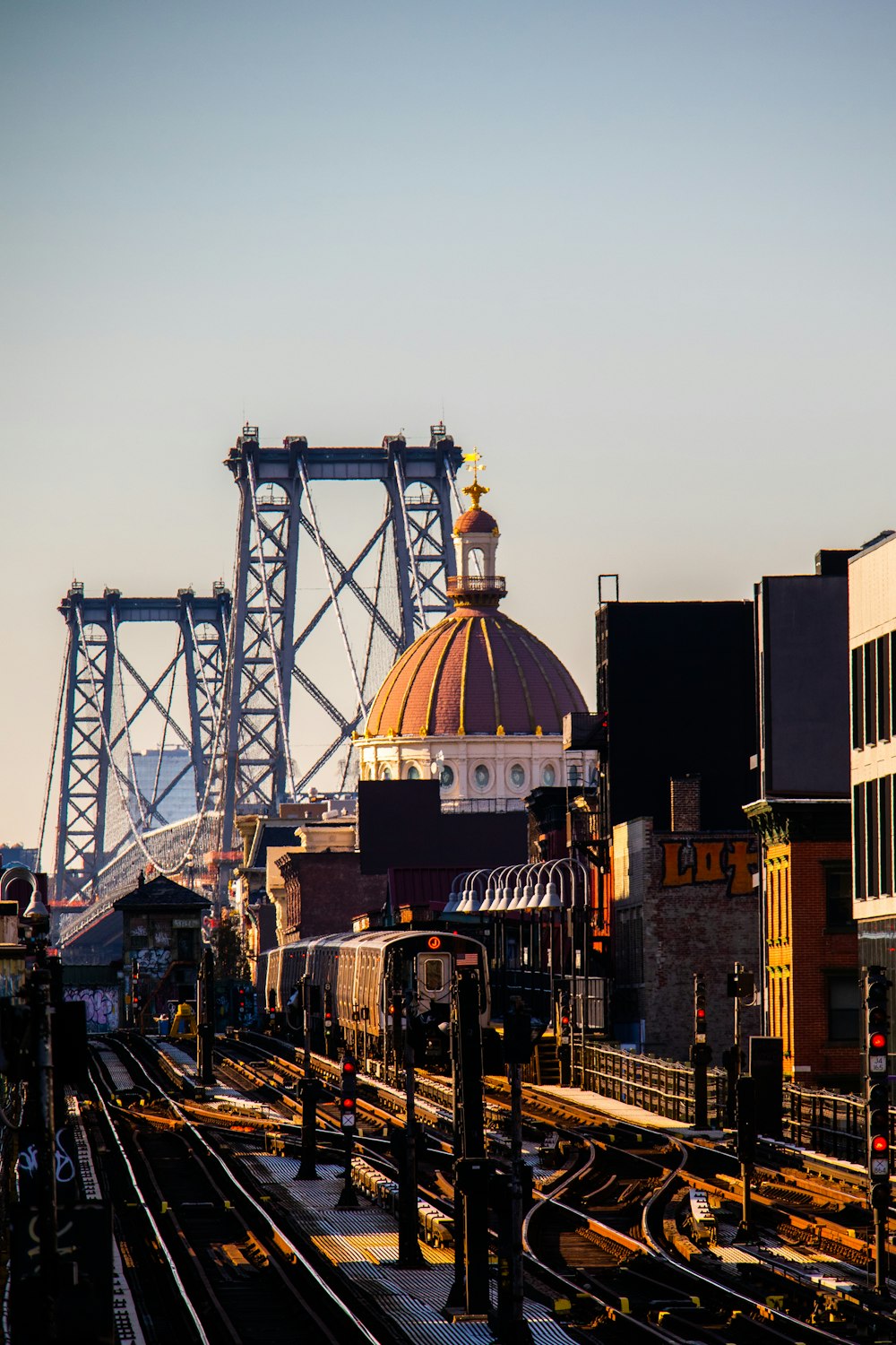 a train traveling down train tracks next to a tall bridge