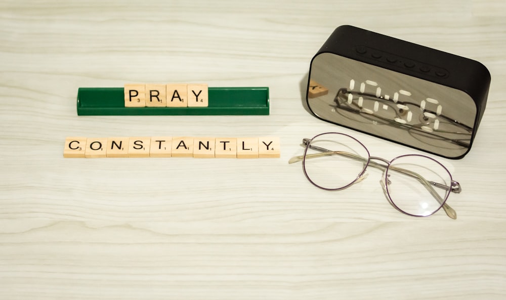 a pair of glasses sitting next to some scrabble letters