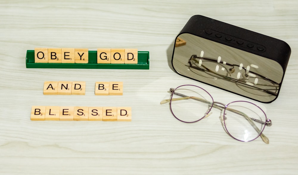 a pair of glasses sitting on top of a table next to scrabble letters