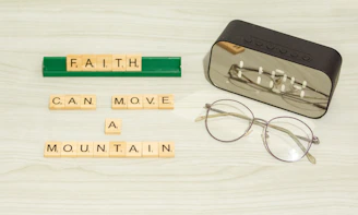 a pair of glasses sitting next to some scrabble letters