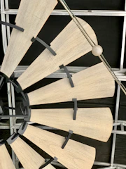 Close-up of a stylish ceiling fan with wooden blades spinning gently.