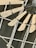 Wooden fan blades attached to a central hub mounted on an industrial-style metal ceiling. The structure consists of metal beams and a string of lights with a single exposed bulb.