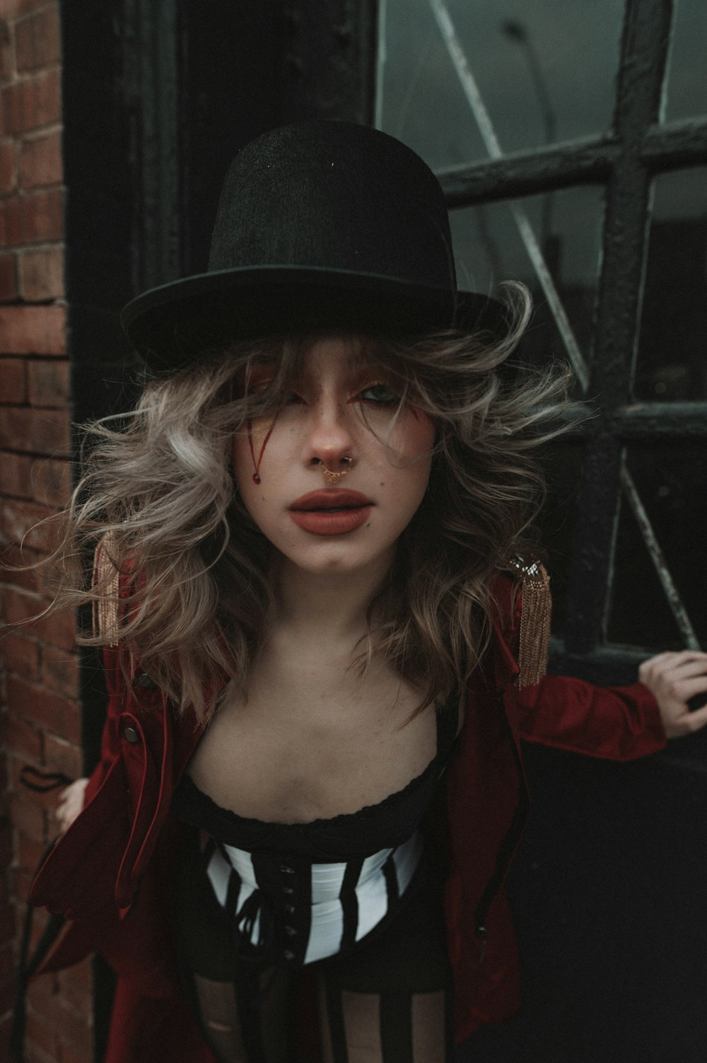 a woman wearing a black hat and a red jacket