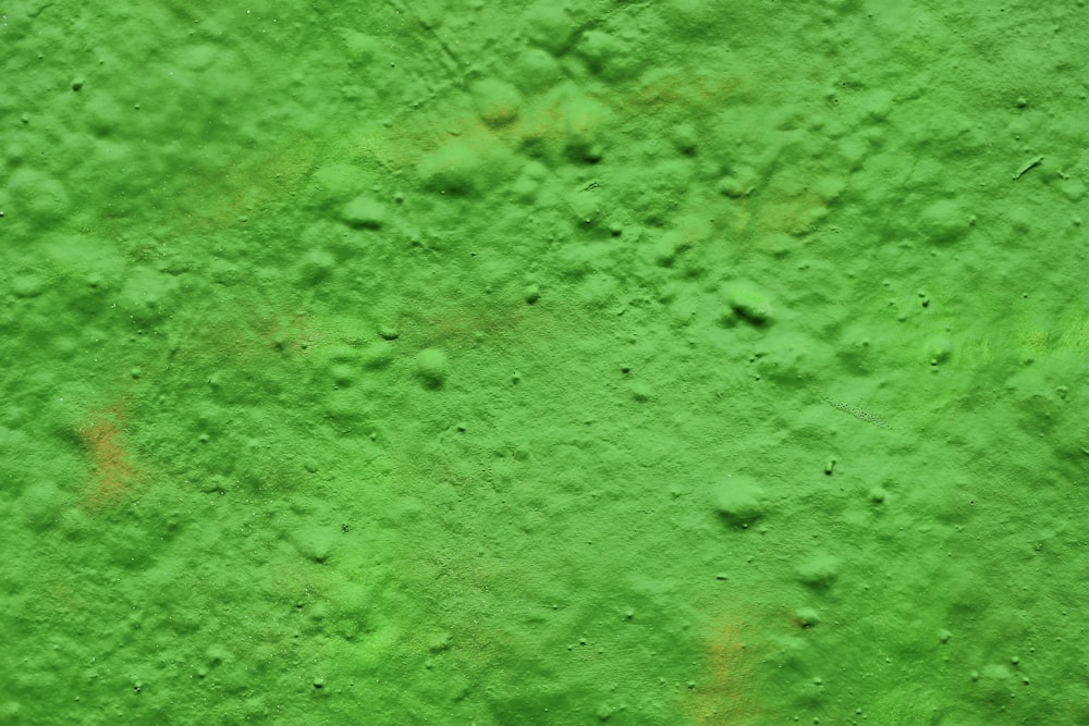 a close up of a wall with green paint