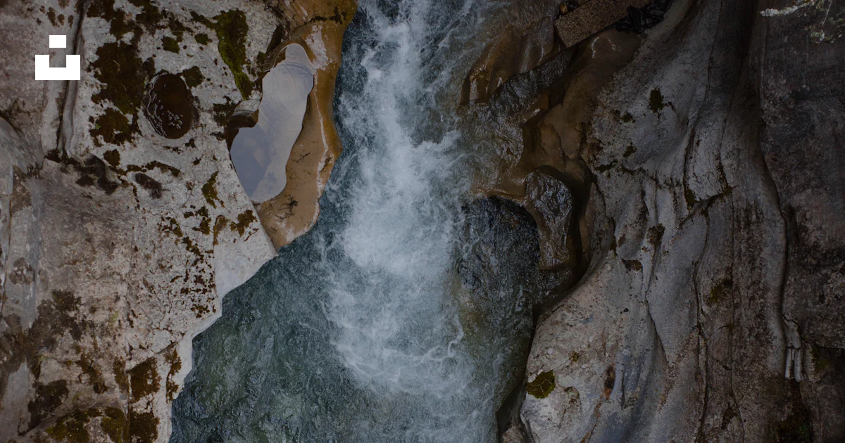 Stream Between Two Rocks A stream of water running between two large rocks photo – Free Grey ...
