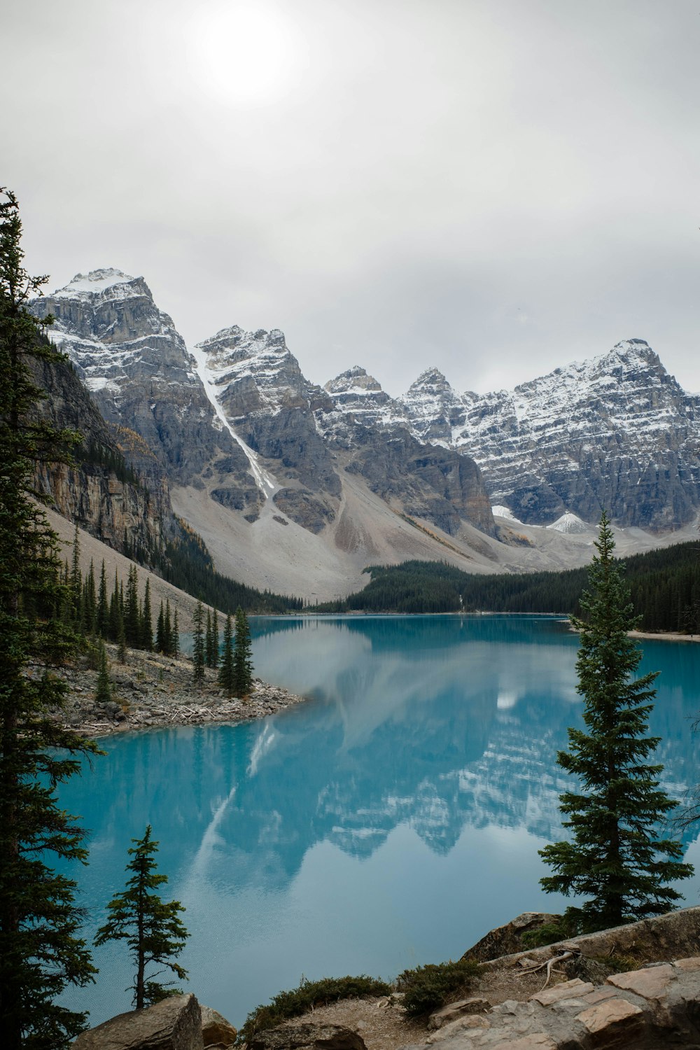 a blue lake surrounded by snow covered mountains