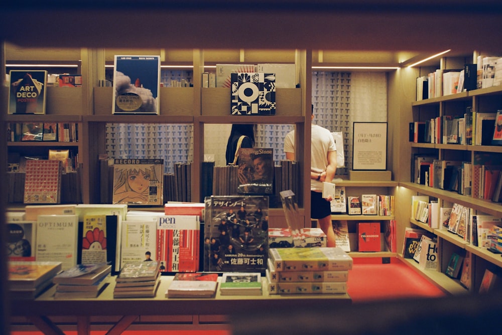 a man standing in front of a bookshelf filled with books