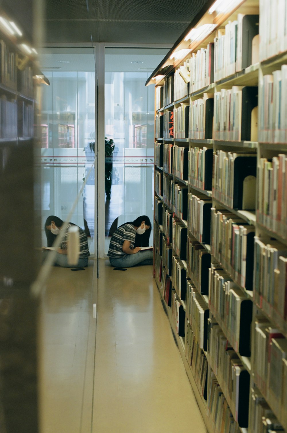 a couple of people laying on the ground in a library