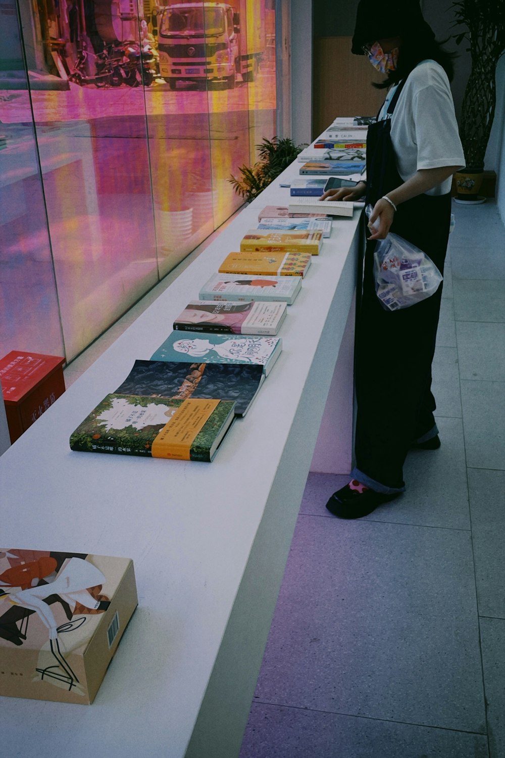 a man standing next to a counter with books on it