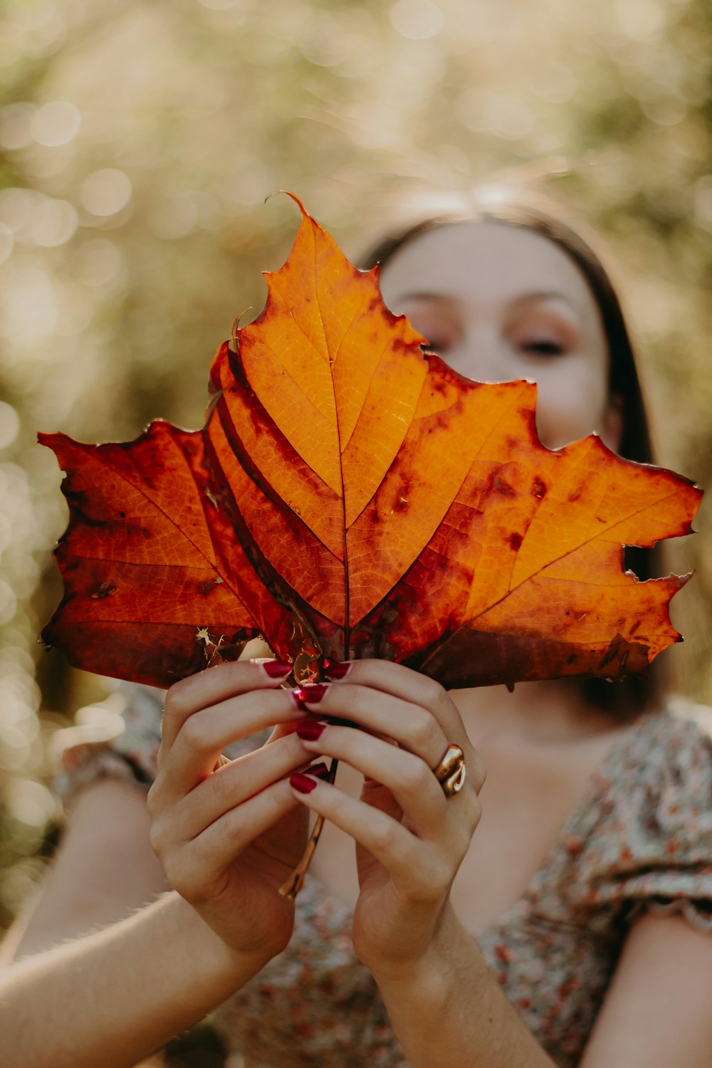 a woman holding a leaf in front of her face