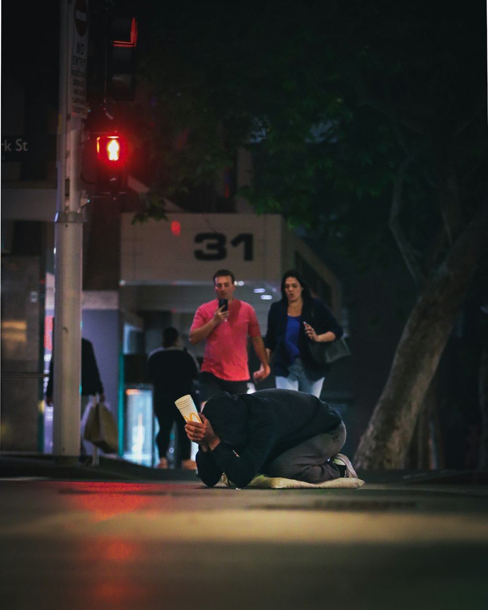 a man kneeling down next to a woman on a street