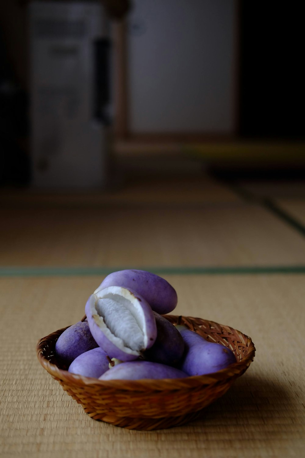 a basket filled with purple fruit sitting on top of a table