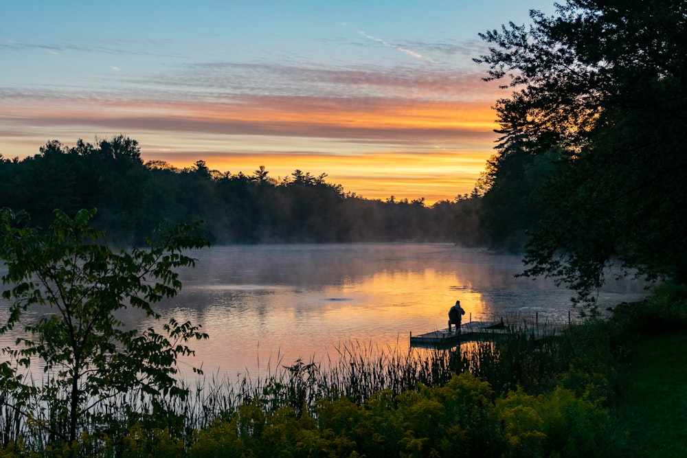 a person standing on a boat in a lake