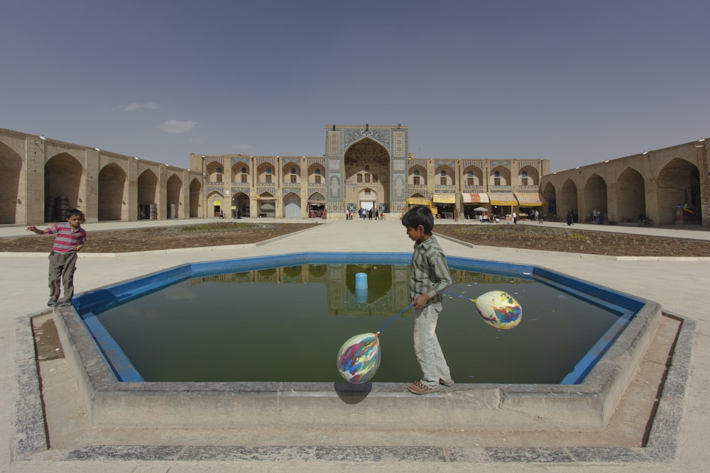 Dos niños juegan en un charco de agua