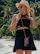 Stylish woman in a modern streetwear look with tropical dark aesthetic, posing on a Rio de Janeiro beach.